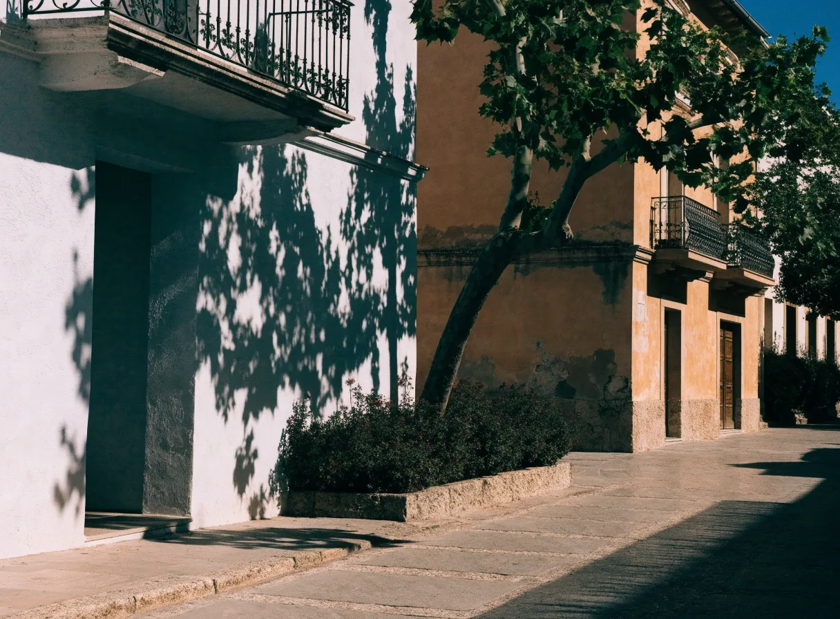 Calle de Colón en Valencia a media tarde, con fachadas encaladas y sombra dura sobre la acera