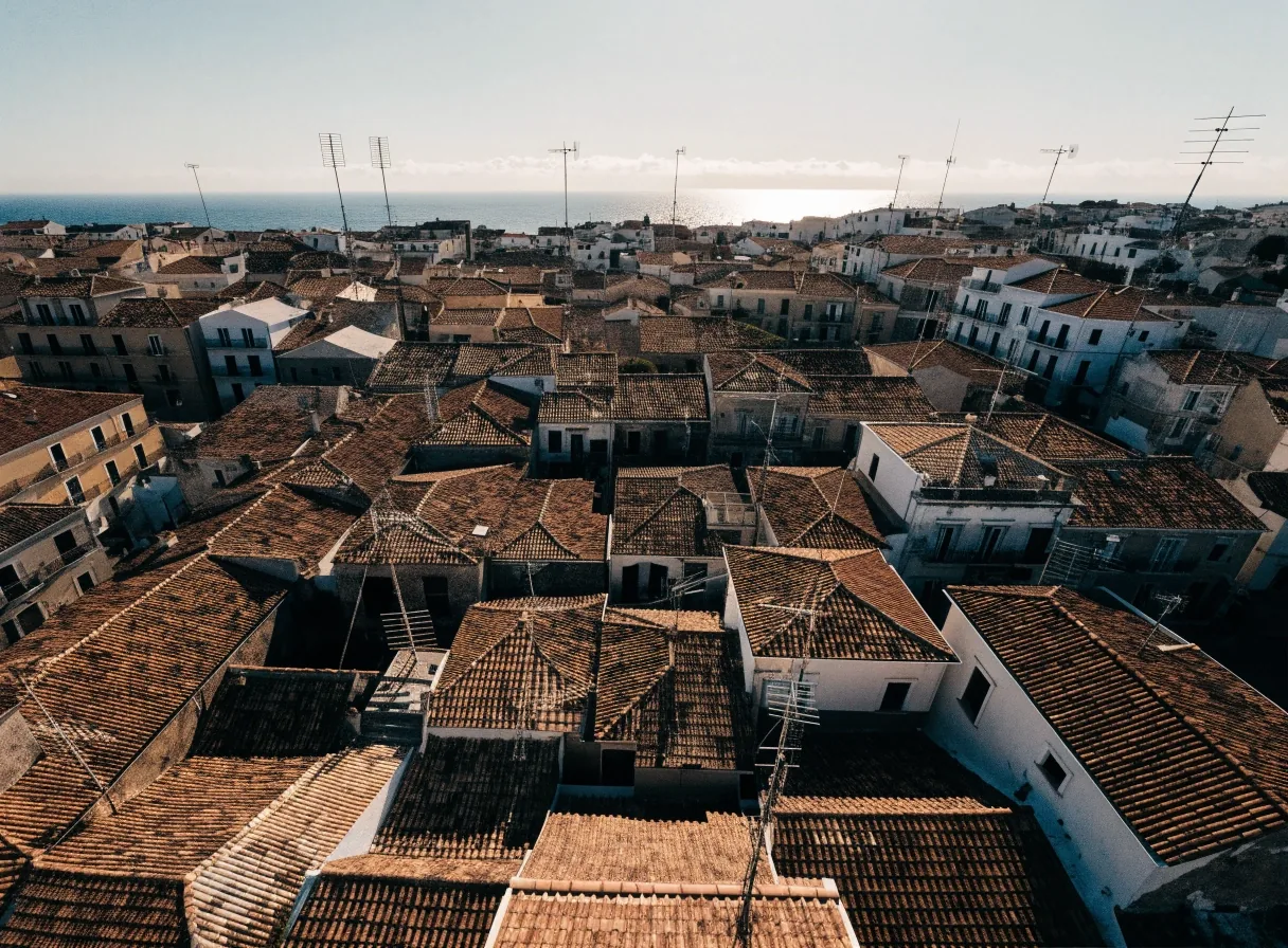 Tejados de una ciudad mediterránea al mediodía, con el mar al fondo