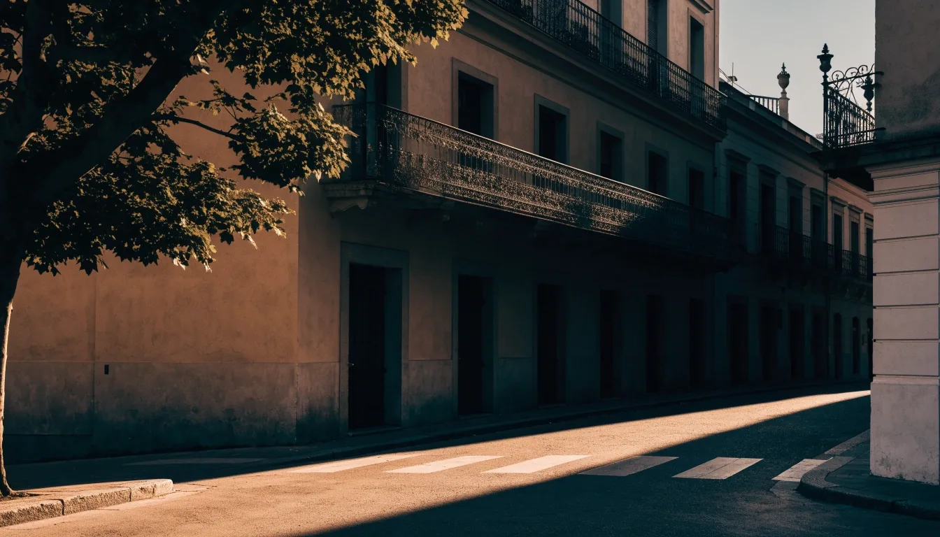 Cruce de calles de una ciudad española a última hora de la tarde, con sombras largas sobre el pavimento